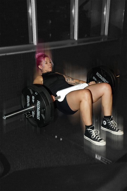 woman doing barbell hip thrusts with uppper barbell pad