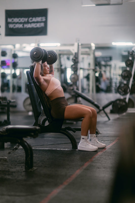 woman doing overhead press with uppper wrist wraps